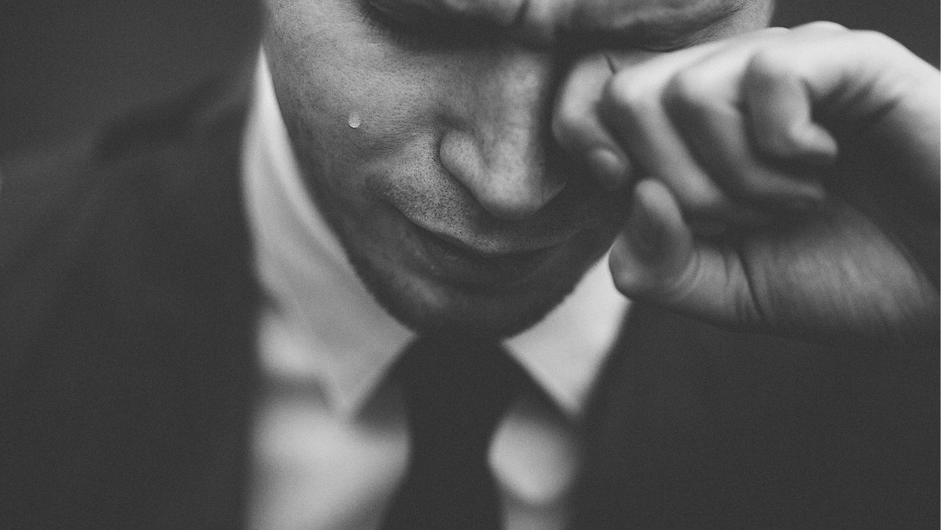 Man rubbing a tear away