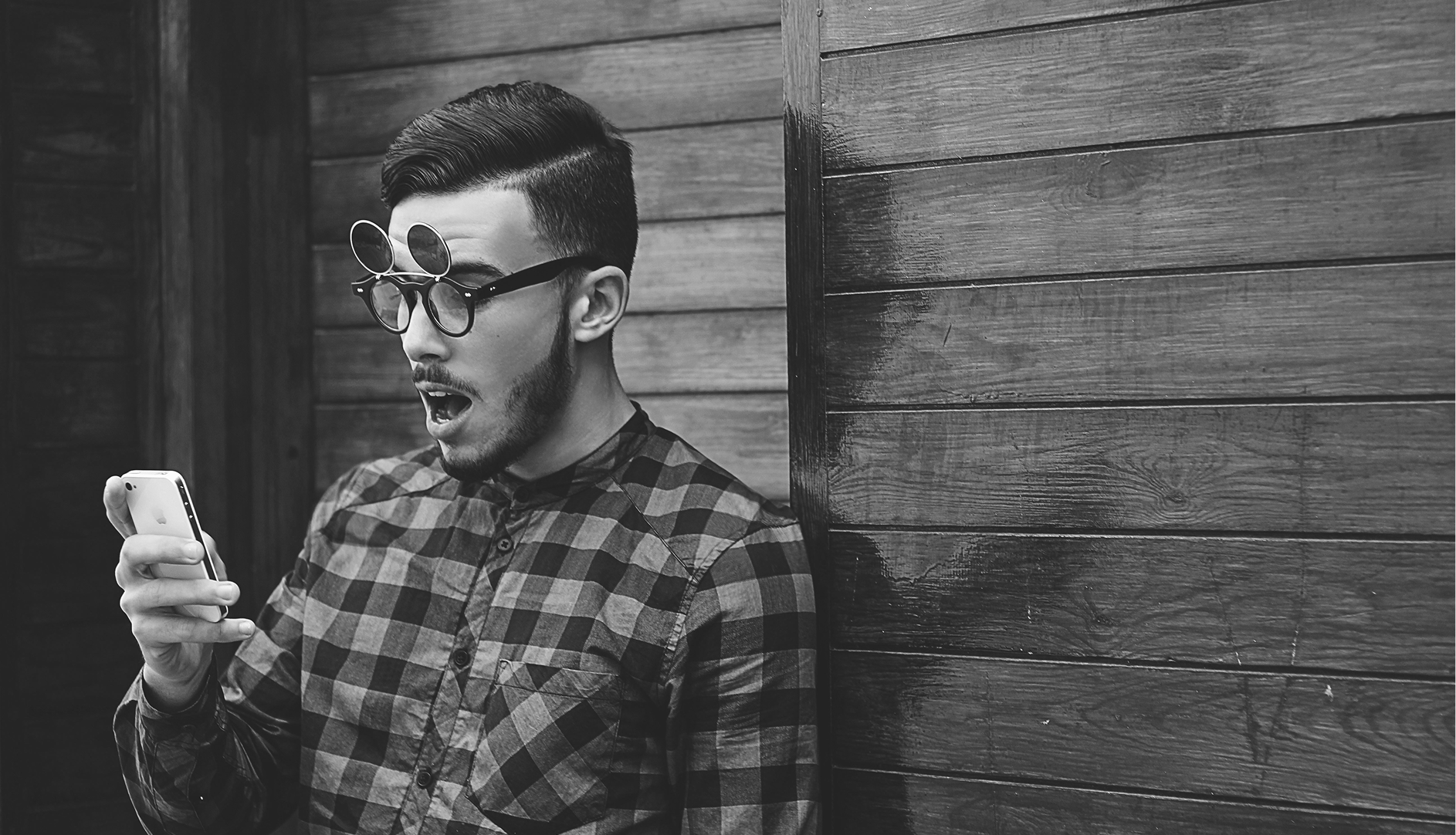 Man looking at phone with shocked expression